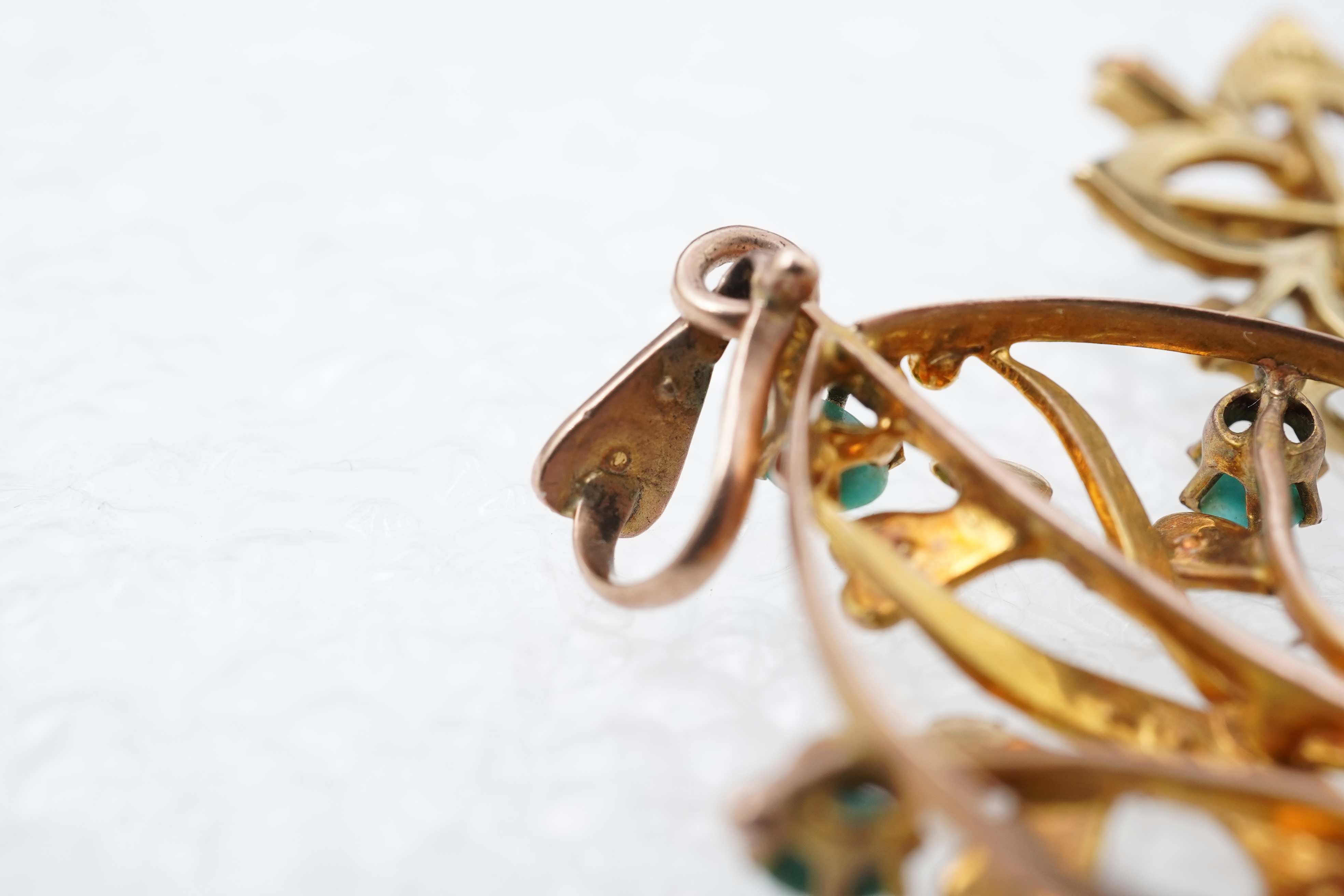 Two Edwardian turquoise and seed pearl pendants, each of foliate design, set with turquoise cabochons and seed pearls, mounted in gold, longest 3.7cm, smaller stamped 15CT, combined gross weight approximately 4 grams